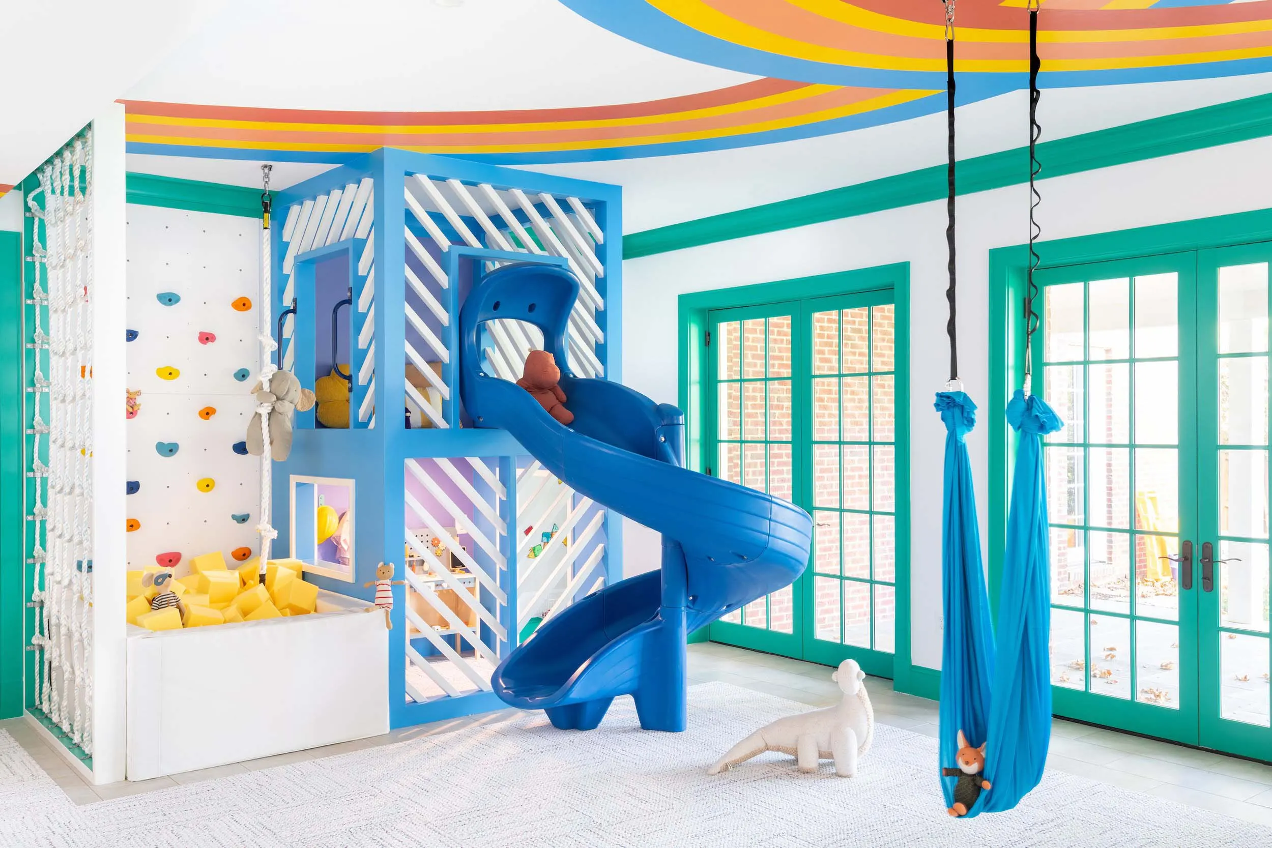 Ribbon mural above a blue play structure and slide