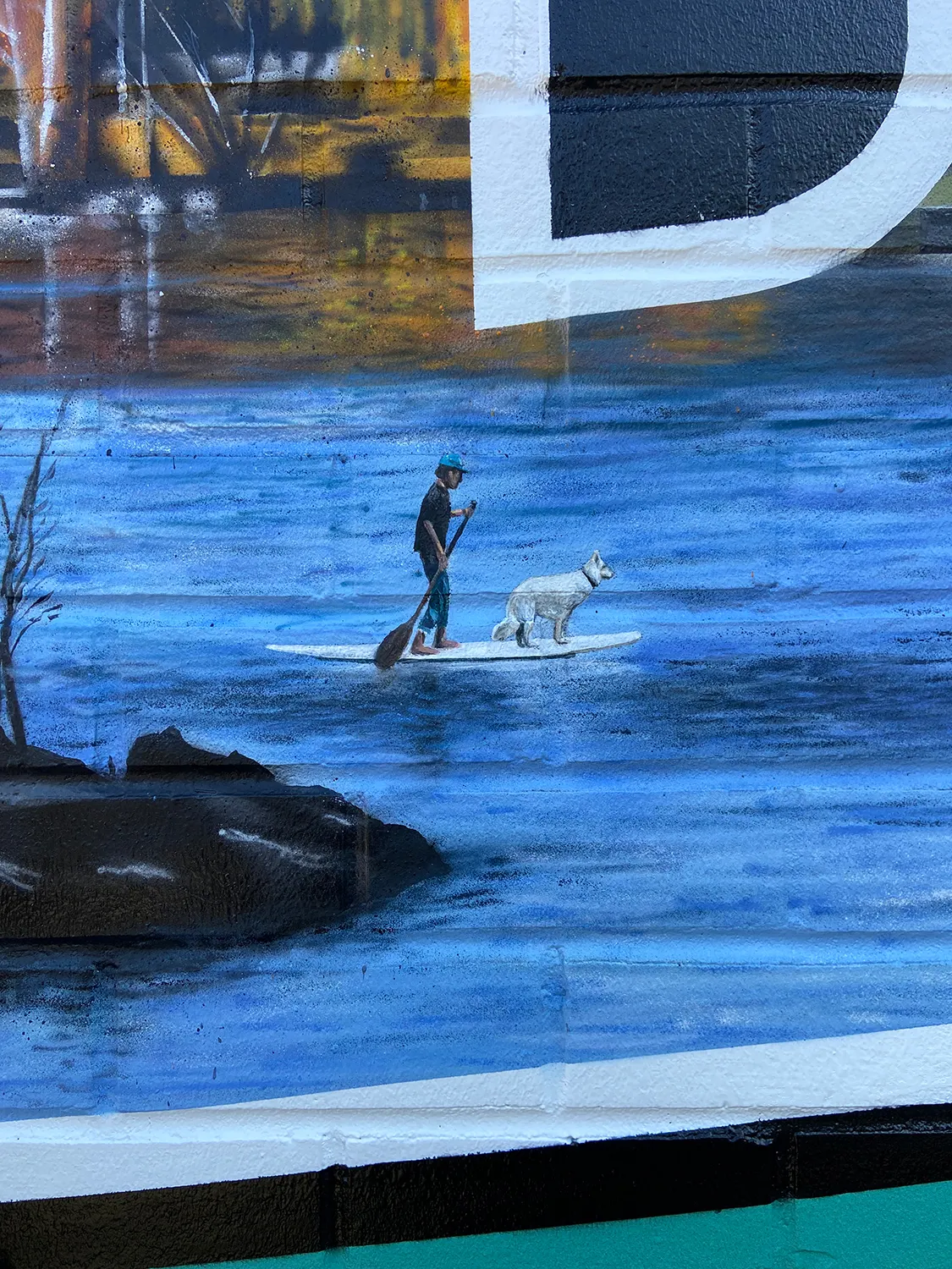Paddleboarder and dog painted on Mirror Pond inside the Bend mural