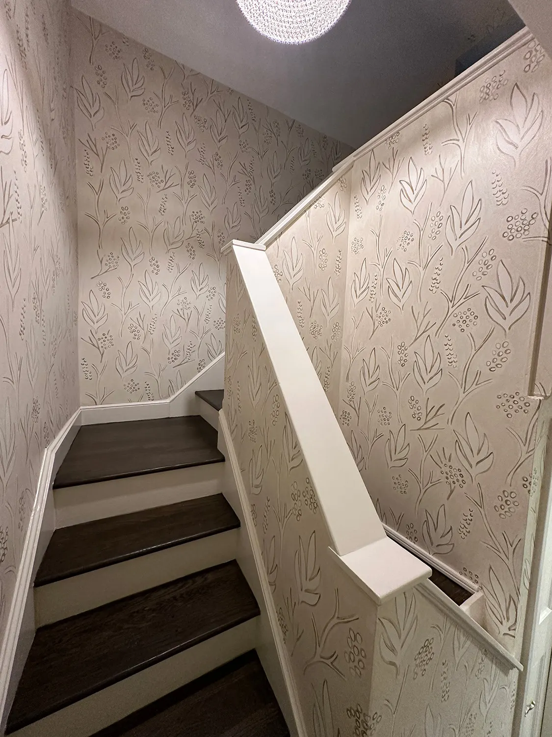 Hand-painted leaf pattern following the walls up a narrow staircase