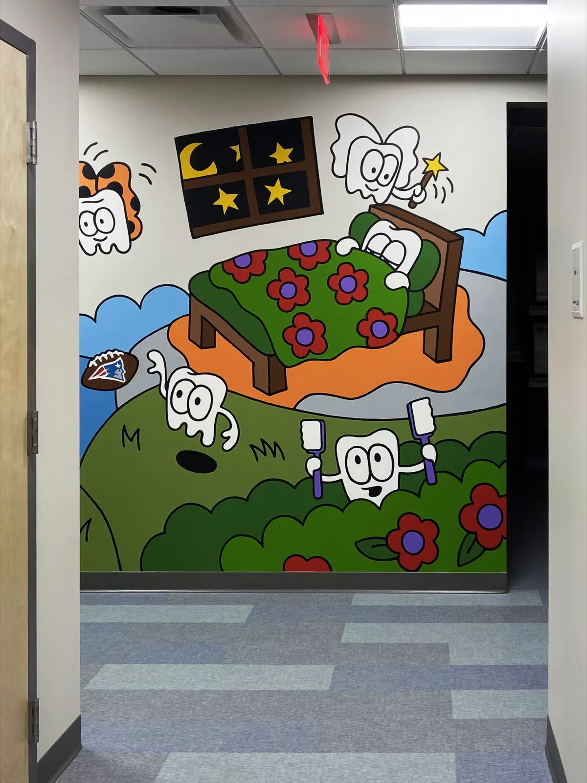 Tooth fairy visiting a sleeping tooth beside a Patriots football and playful characters in the Greater Boston Smiles mural