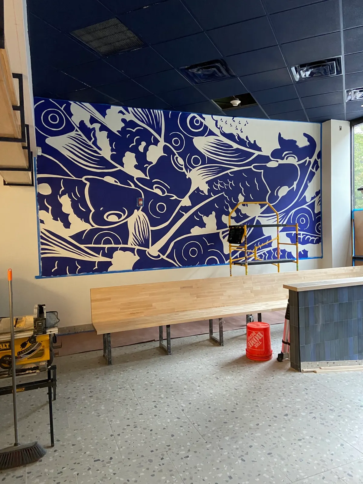 Koi mural in progress with white linework and negative space taking shape