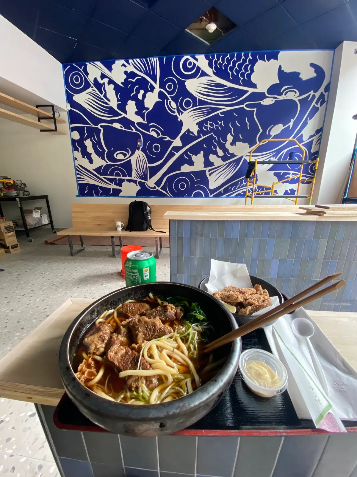 Bowl of Futago Udon in the foreground while the Kenzoku koi mural is being painted next door