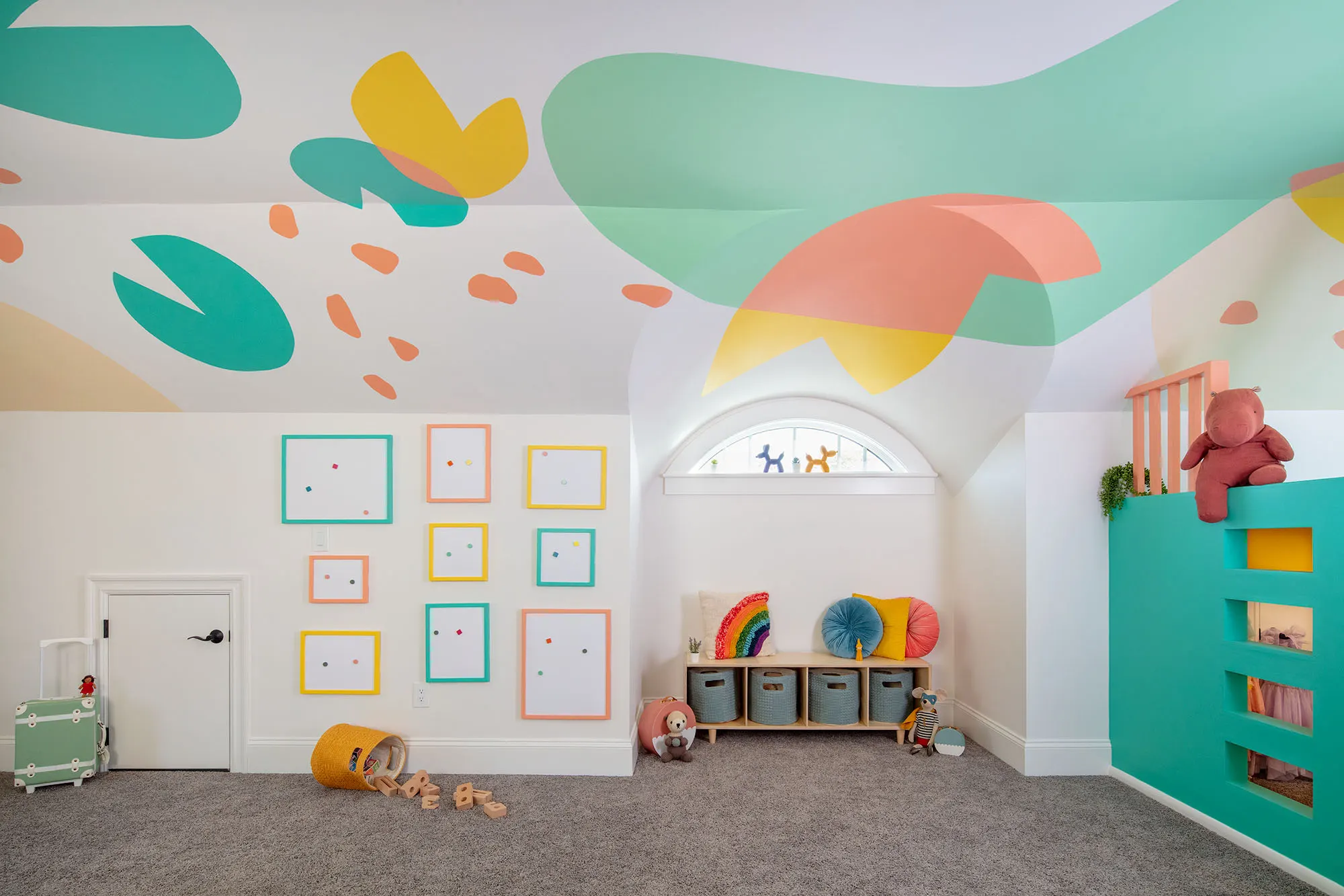 Teal, green, orange, and pink ceiling shapes above the playroom wall