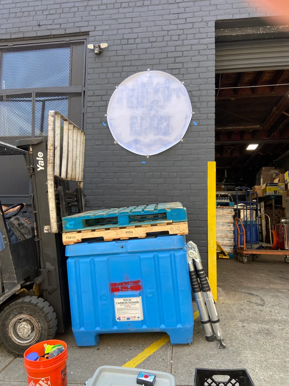 Full-size pounce pattern taped to brick before the Nuts4Nuts sign was painted