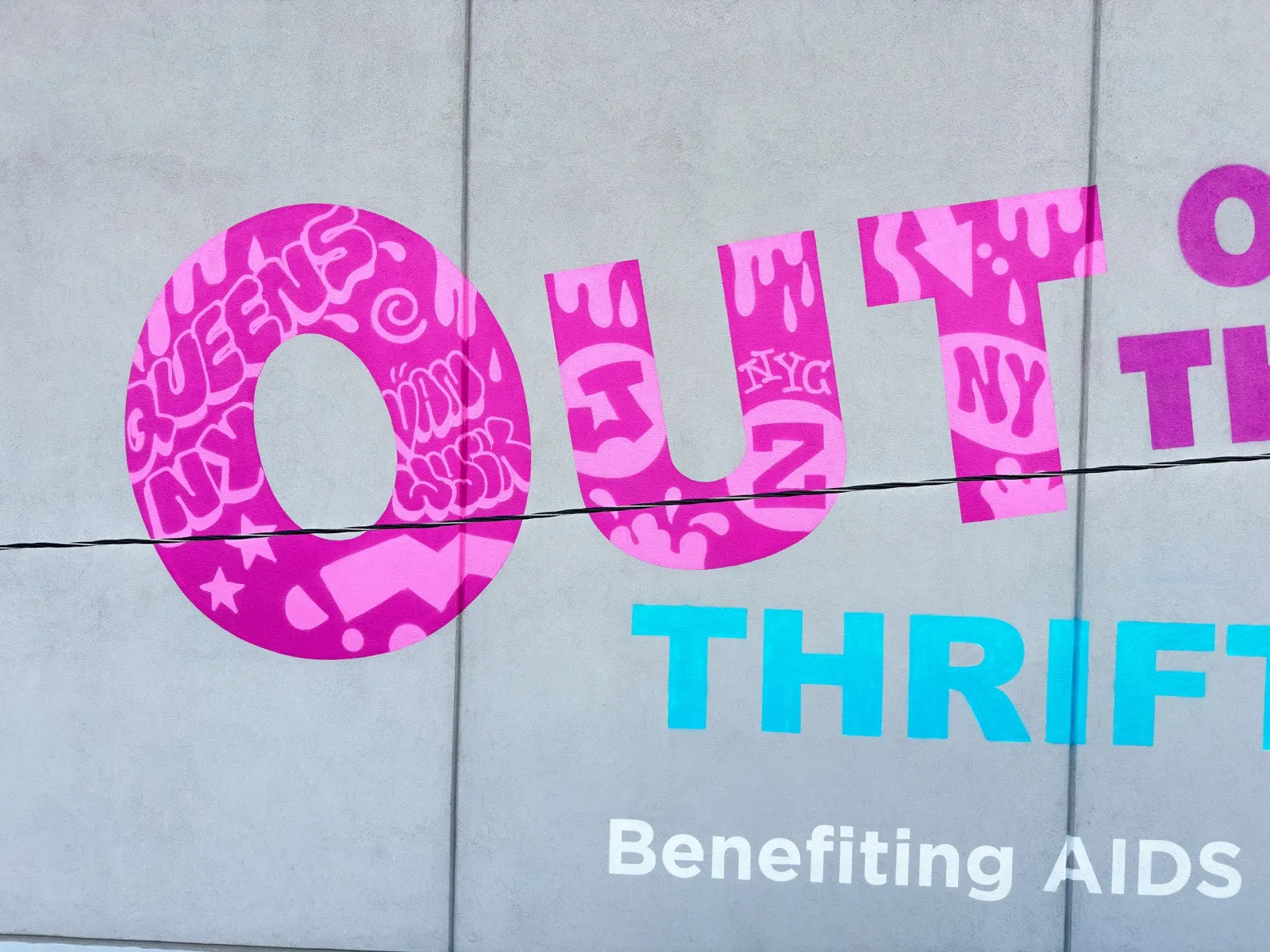 Close view of the finished pink Out lettering filled with graffiti details above turquoise Thrift text