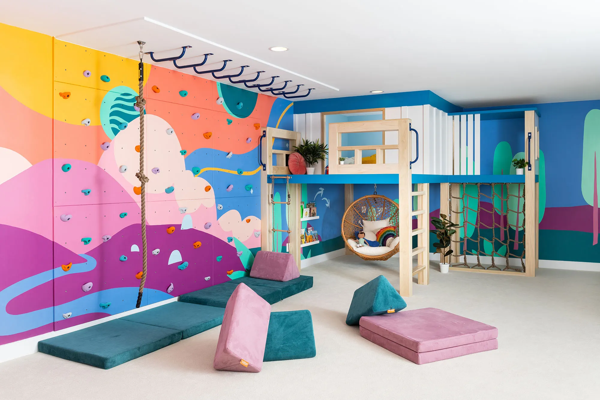Fairfax playroom with a colorful landscape mural around a built-in treehouse