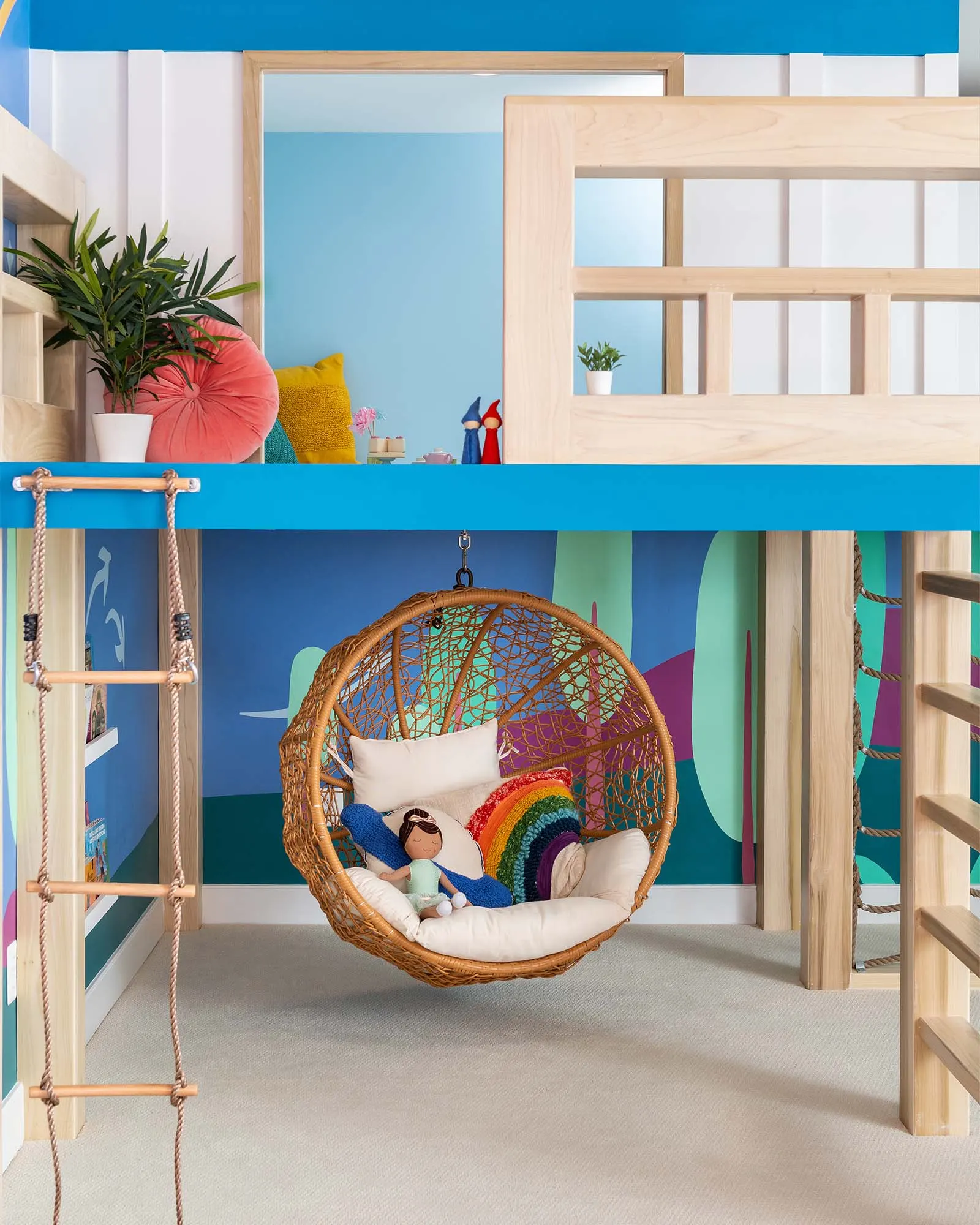 Hanging chair and climbing ropes inside the painted treehouse area