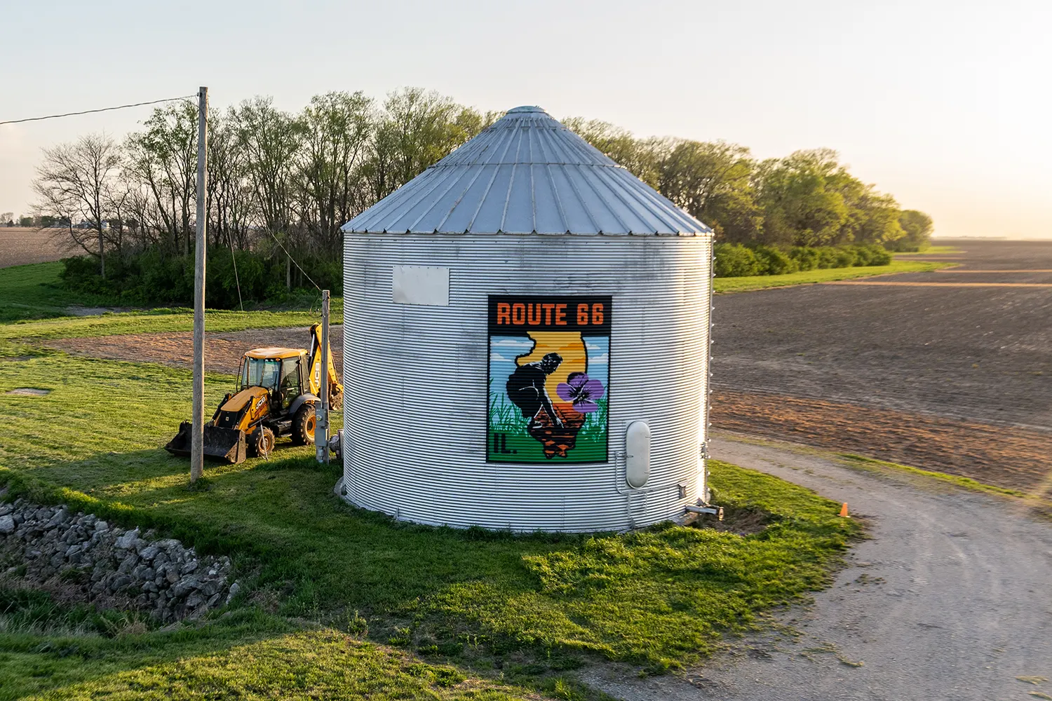 Aerial view of the Route 66 travel-decal mural on a white roadside silo