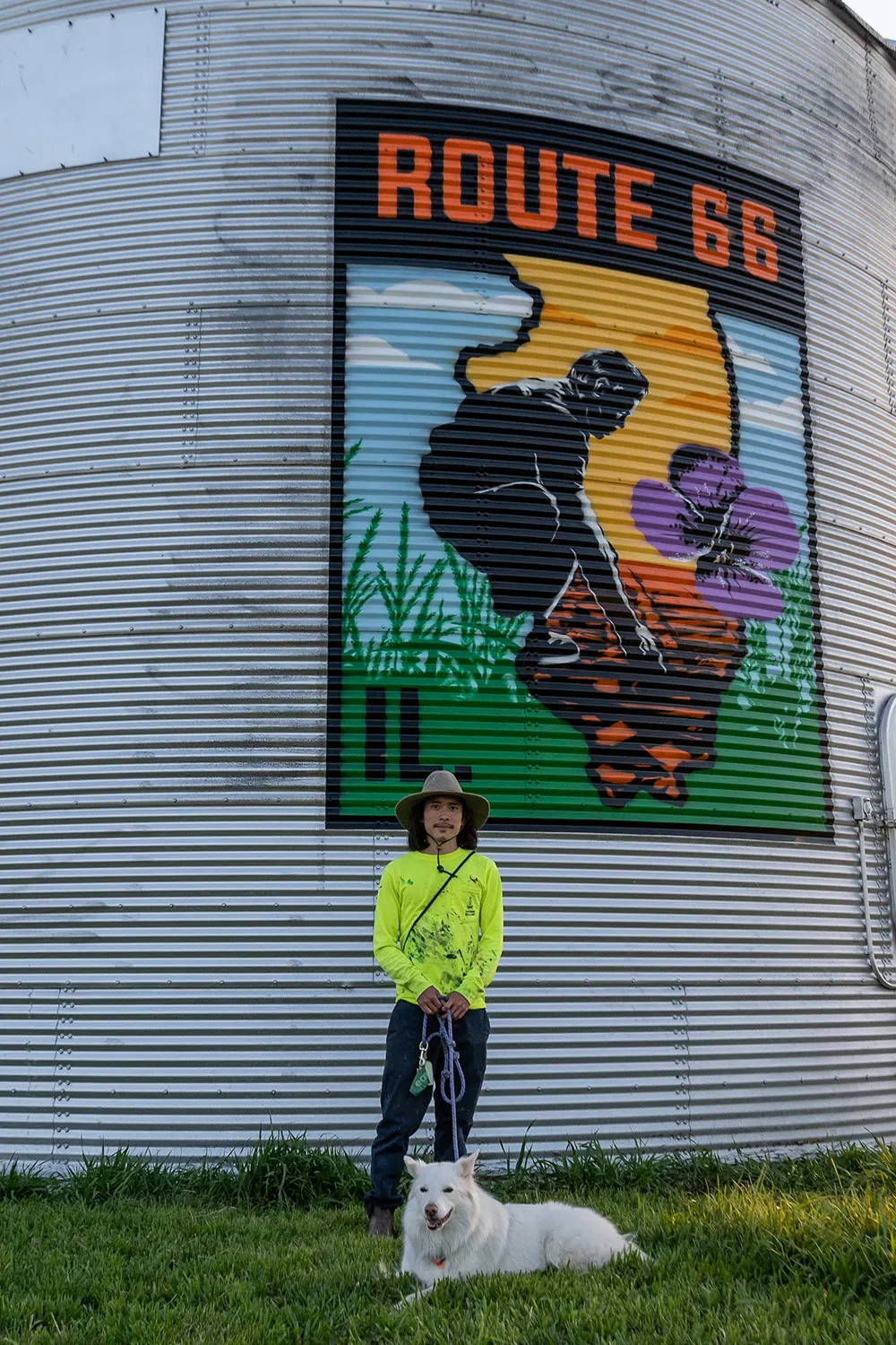 Painter and dog standing below the completed Route 66 design