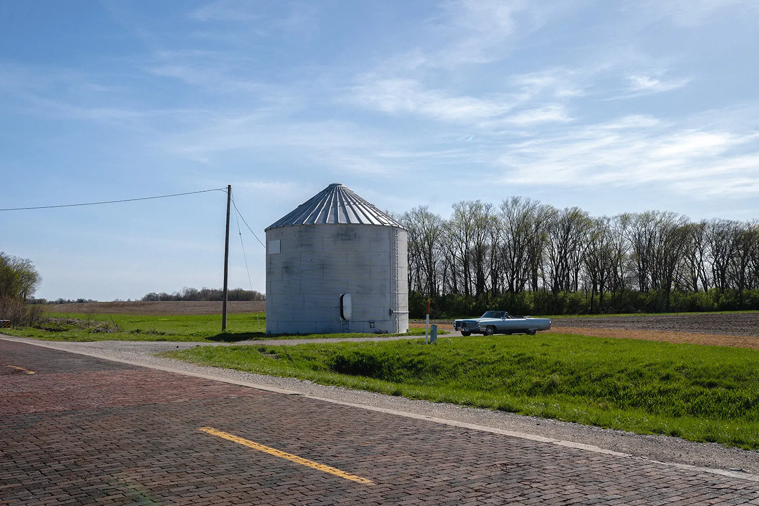 Wide roadside view of the white silo and historic brick pavement