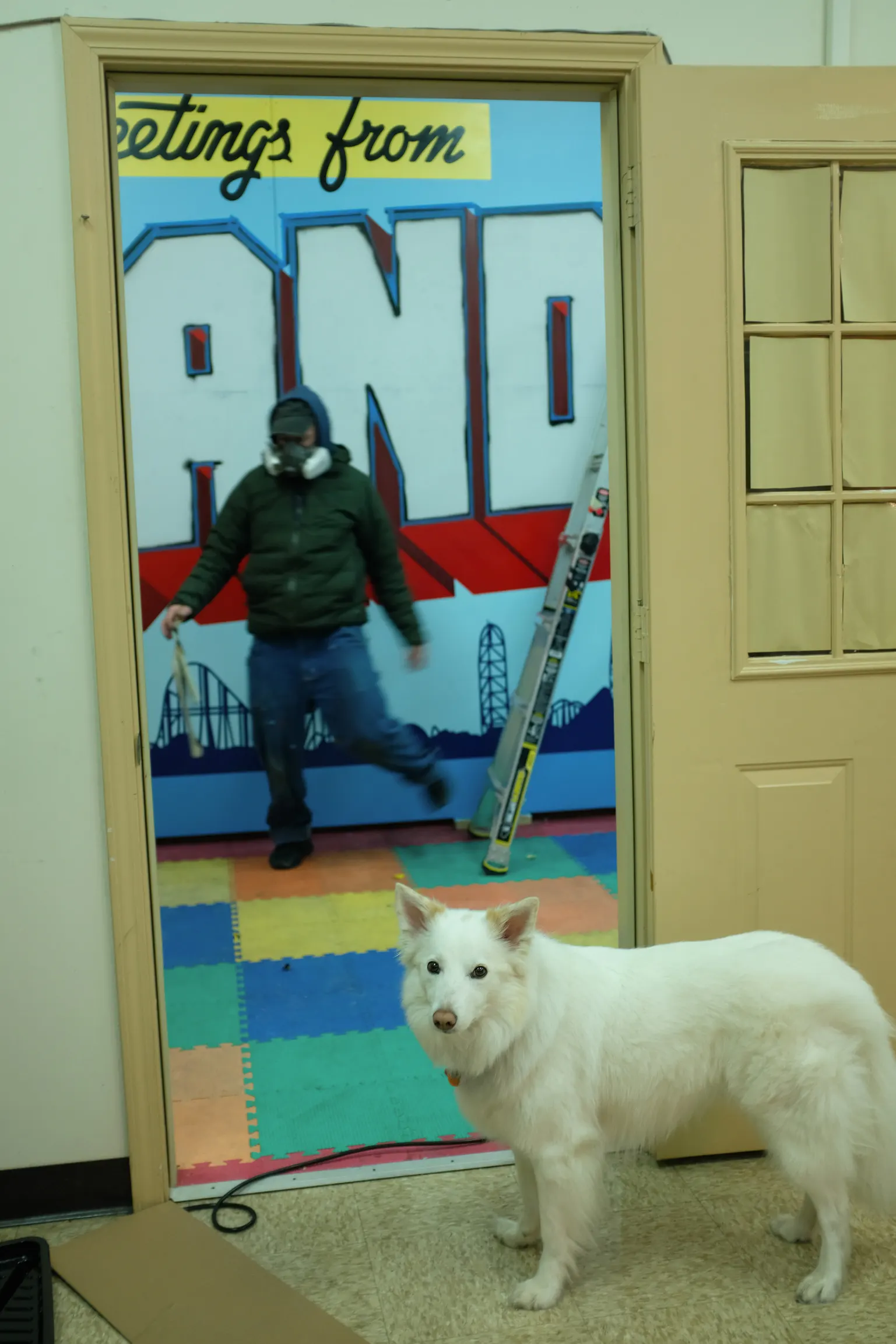 Lead painter and white dog beside the partly painted Sandusky panels