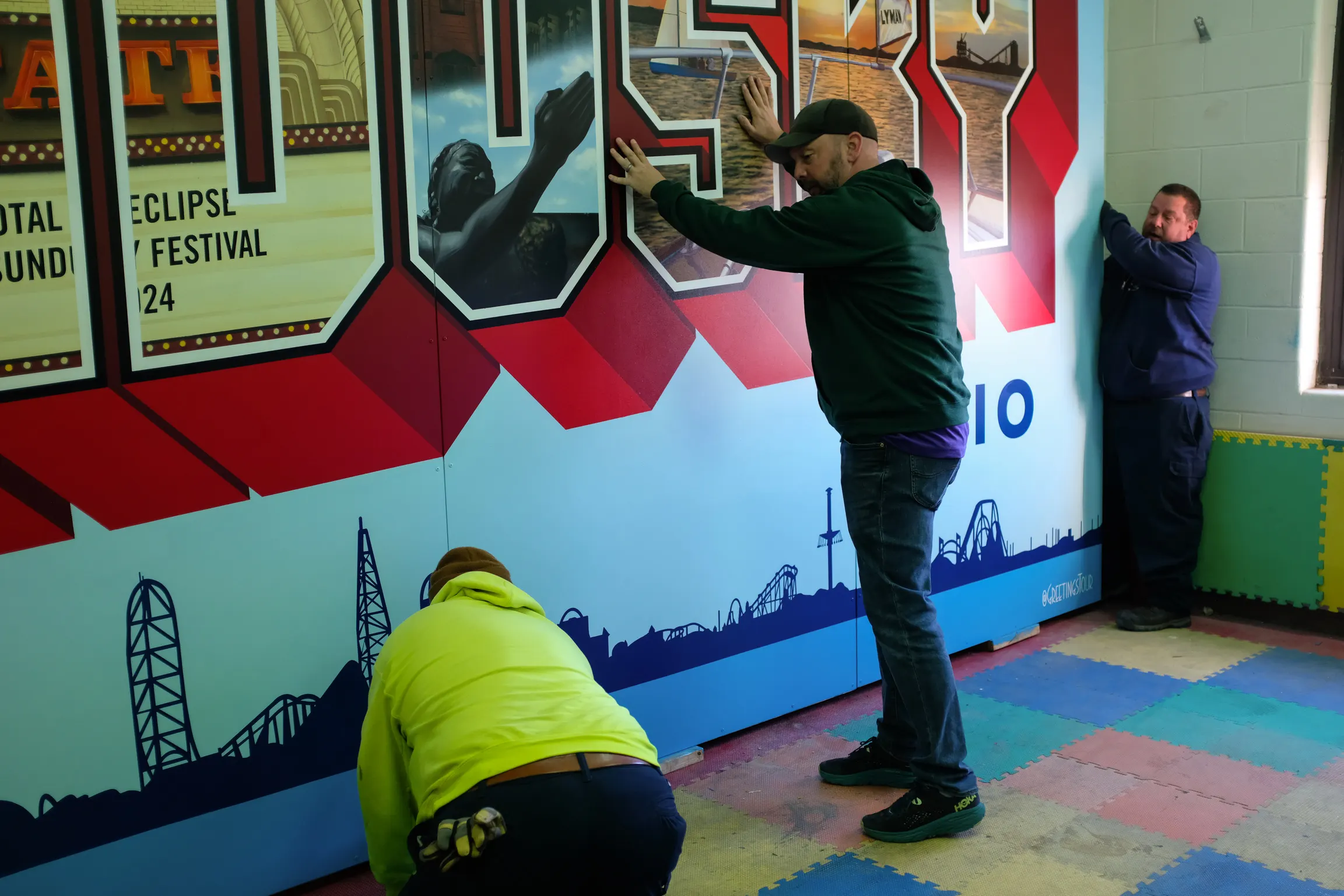 Artists finishing the panel seams and letter details before installation