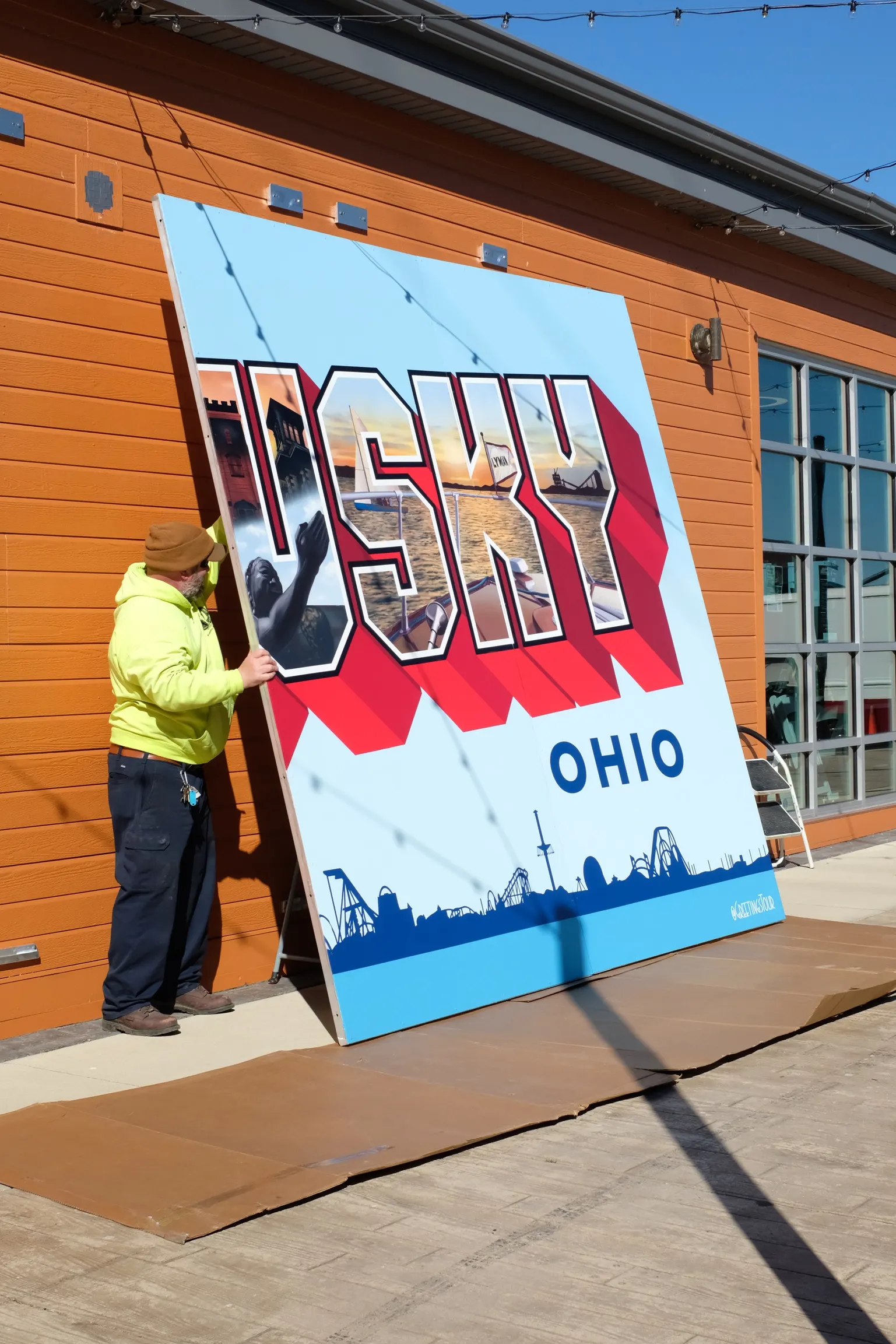 Crew lifting a finished Sandusky panel into its exterior frame