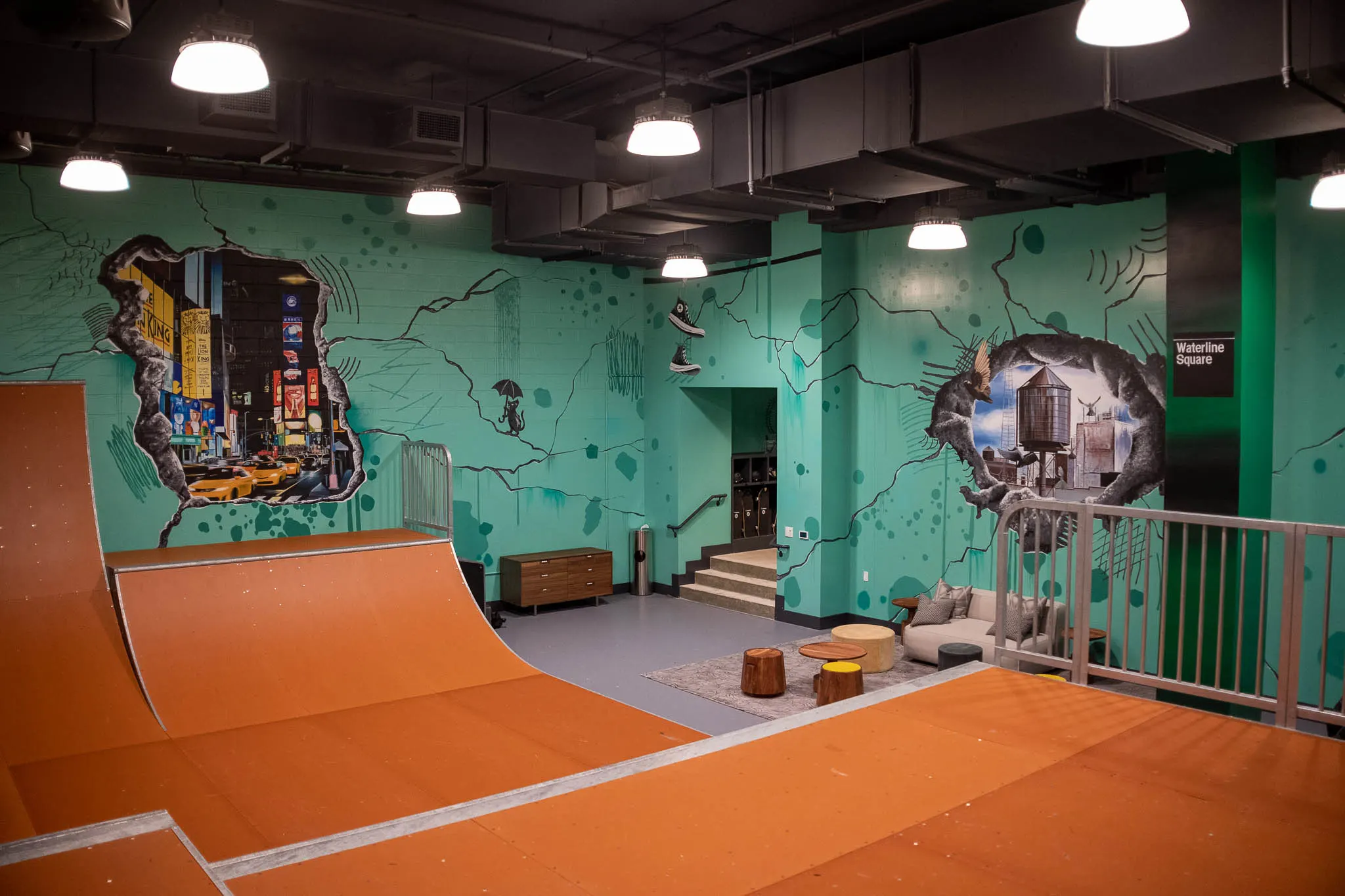 Indoor skatepark with several New York scenes painted around the ramps