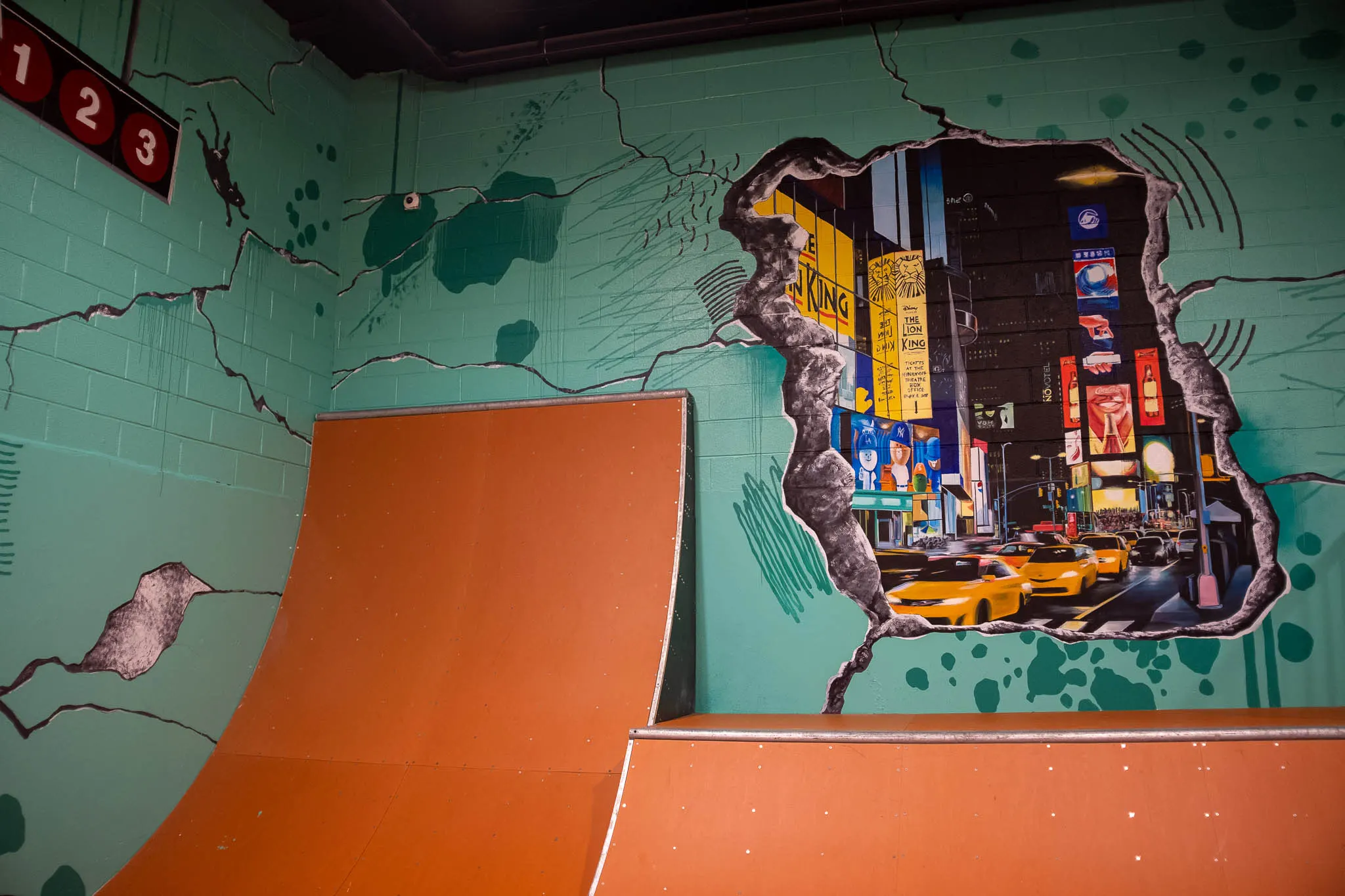 Times Square taxis and signs painted inside a broken-wall opening