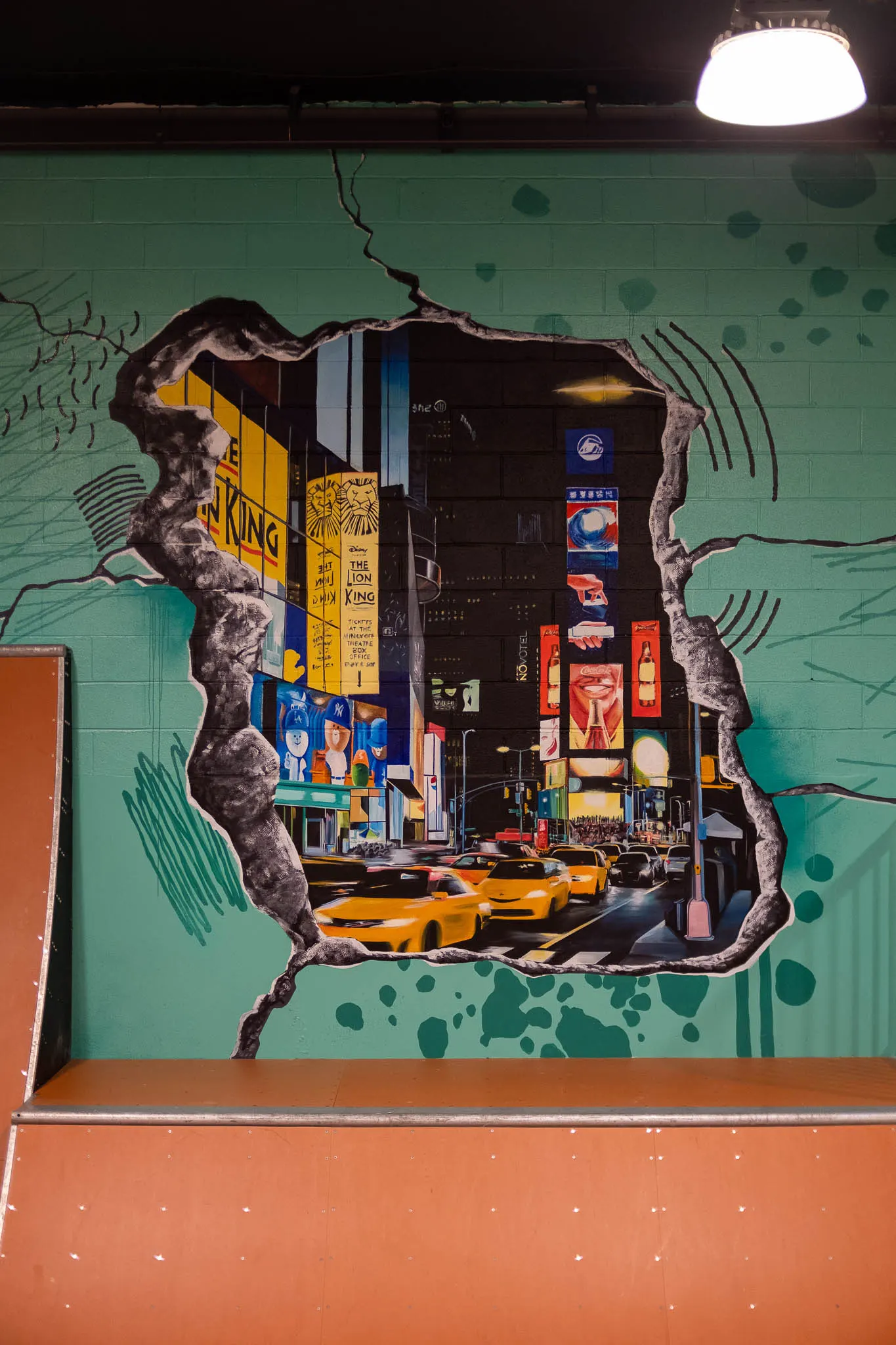 Times Square mural beside an orange skate ramp