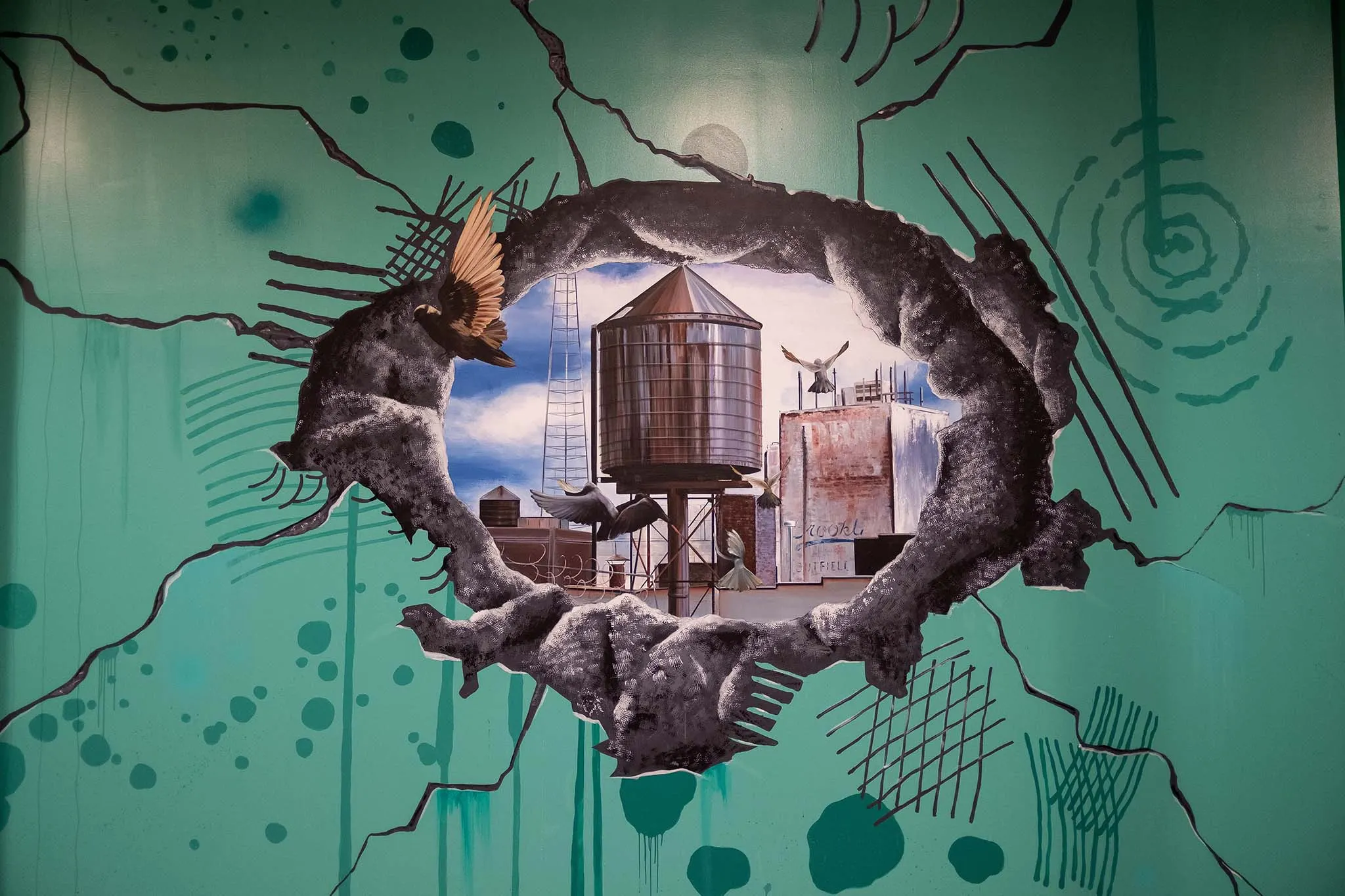 Classic rooftop water tower painted inside a cracked-wall frame