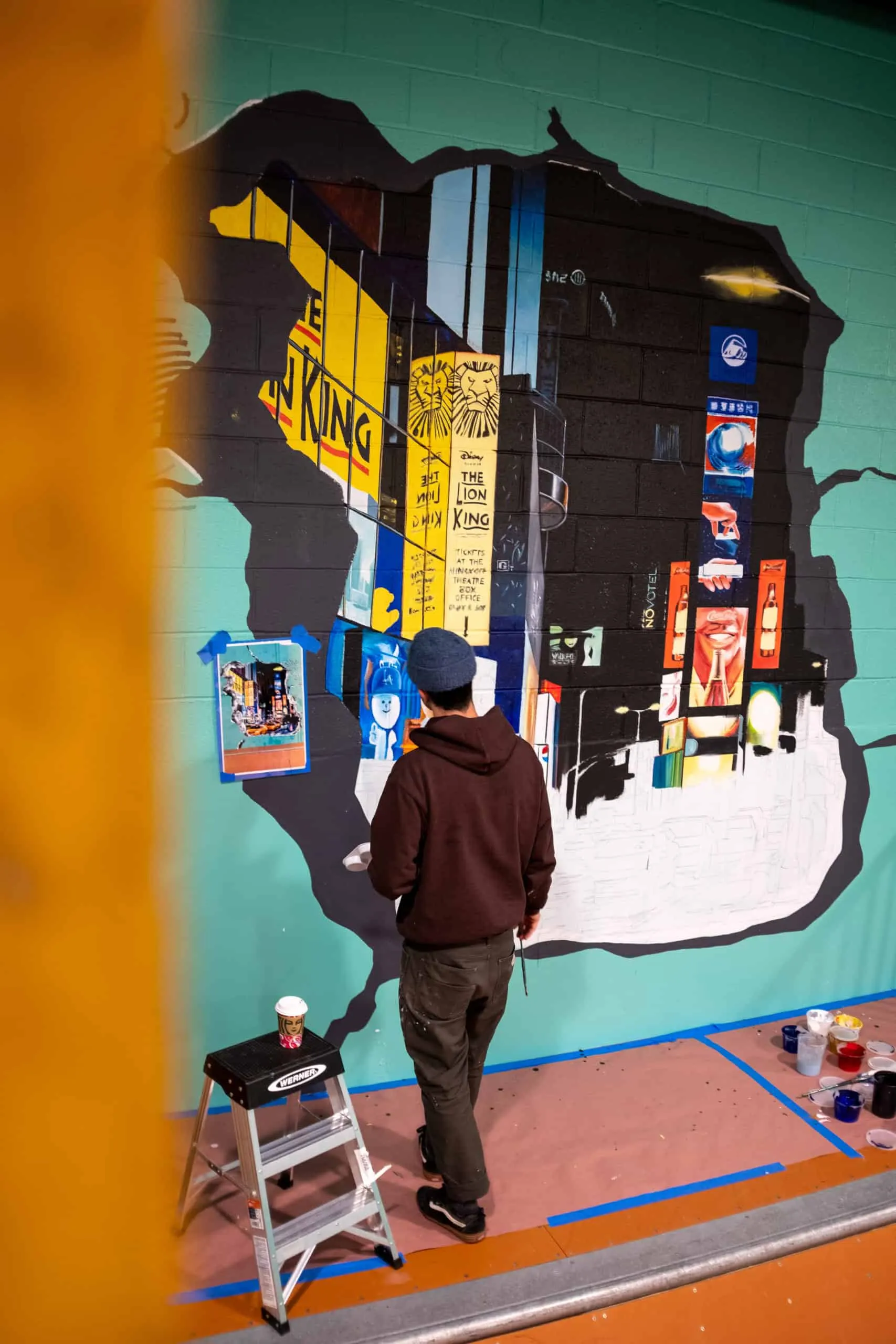 Artist painting the Times Square scene from a step ladder