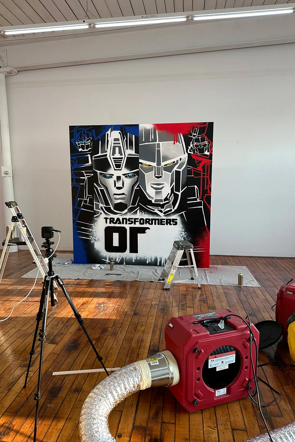 Transformers One event backdrop being spray-painted in the studio