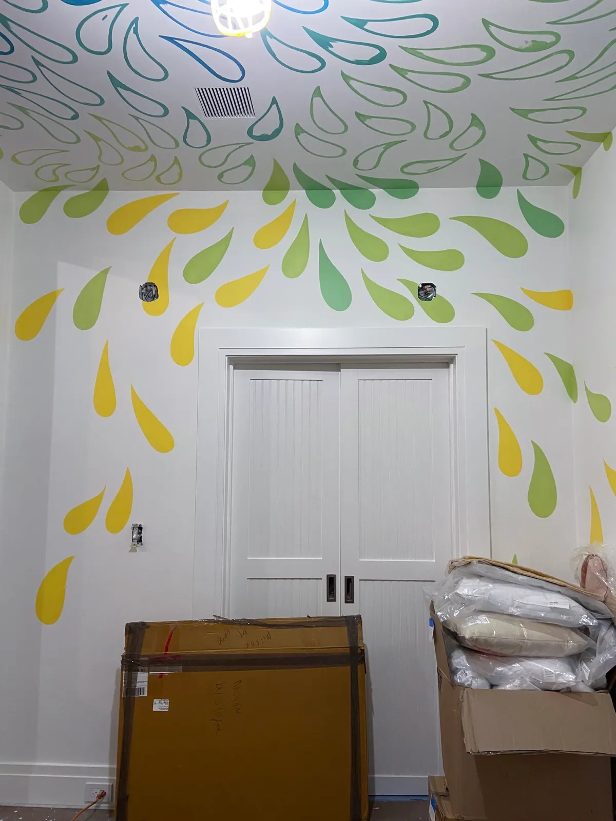 Green and yellow drop pattern continuing from the ceiling onto the playroom walls