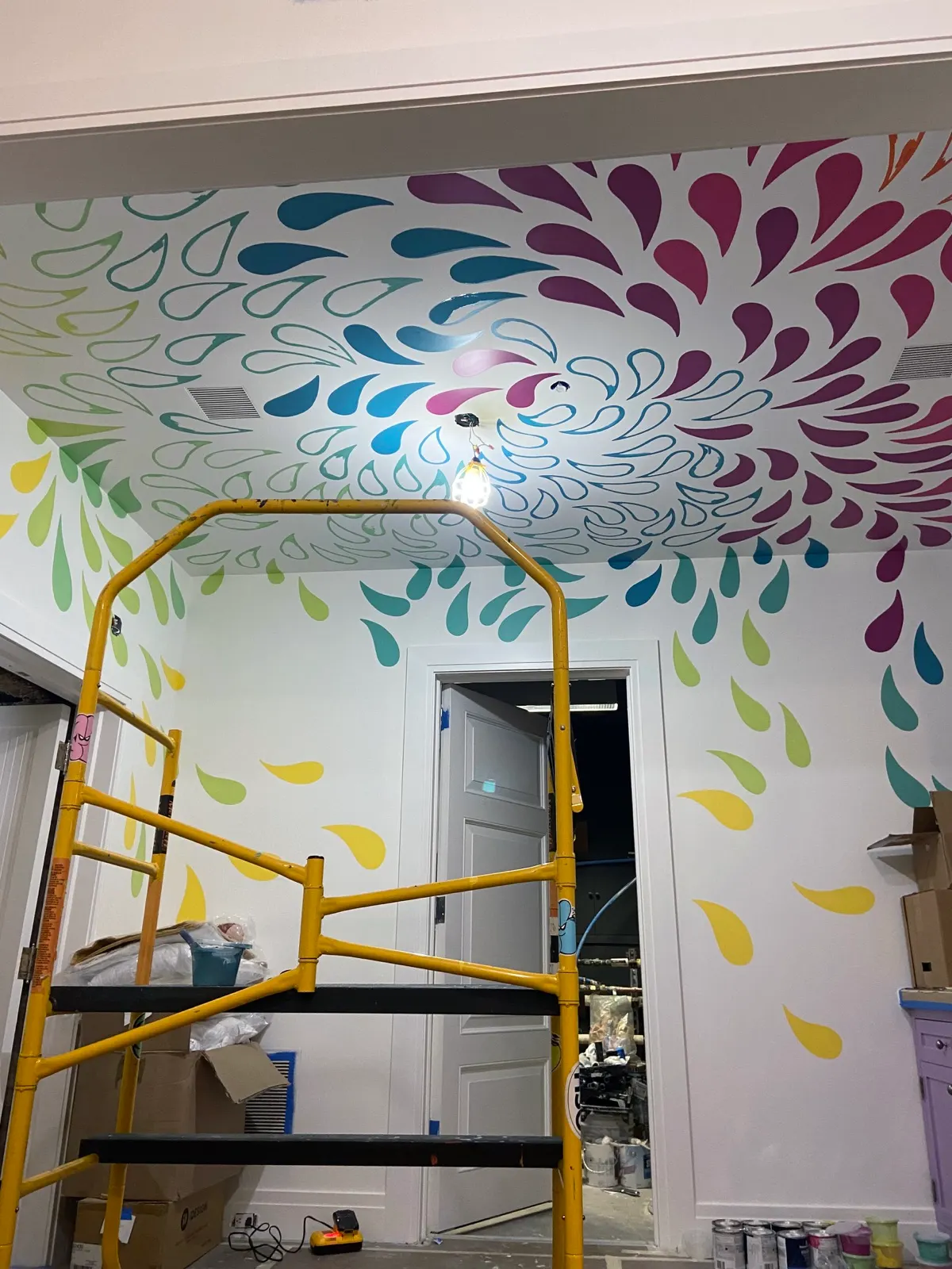 Multicolored drop mural spreading across the ceiling and walls of a second Tribeca playroom