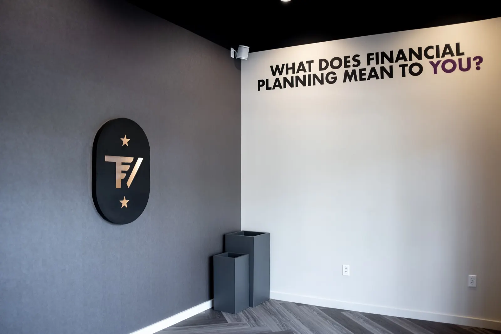 TrueView logo plaque beside the hand-painted financial planning question in a gray and white office corner