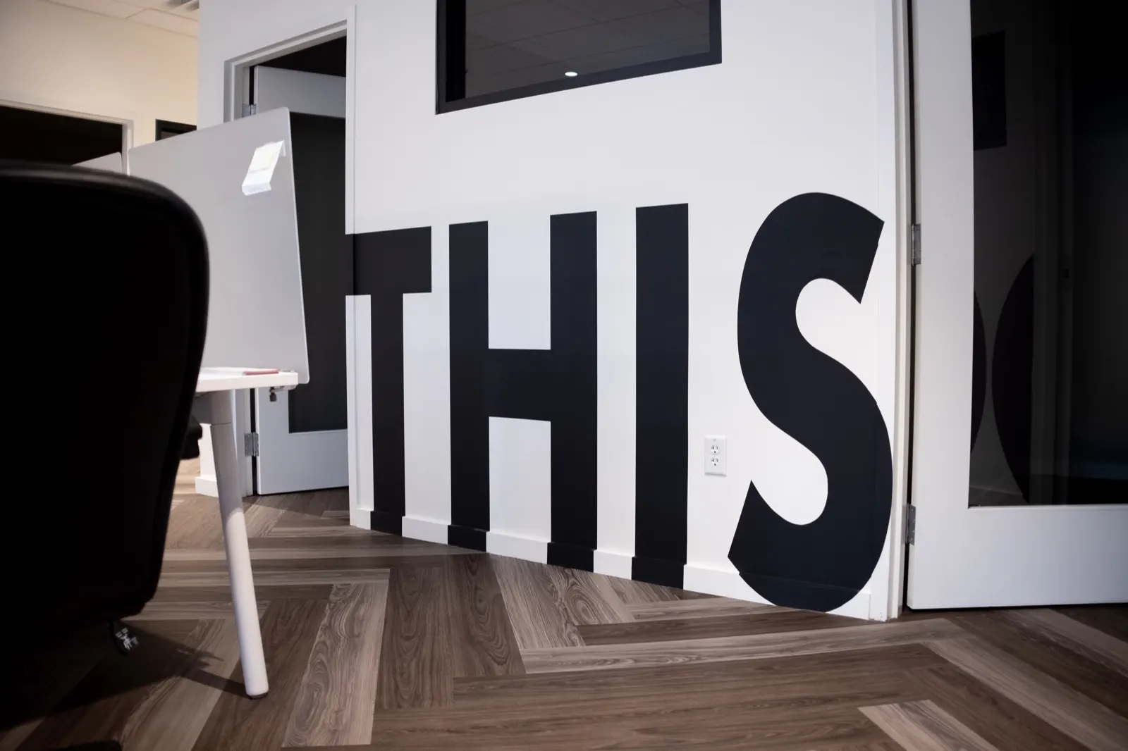 Oversized black This lettering wrapping an office doorway