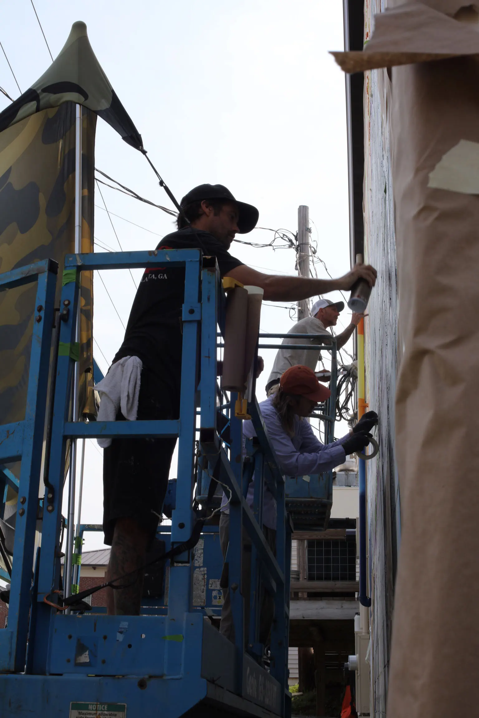Artist masking and painting a crisp edge on the Union County mural
