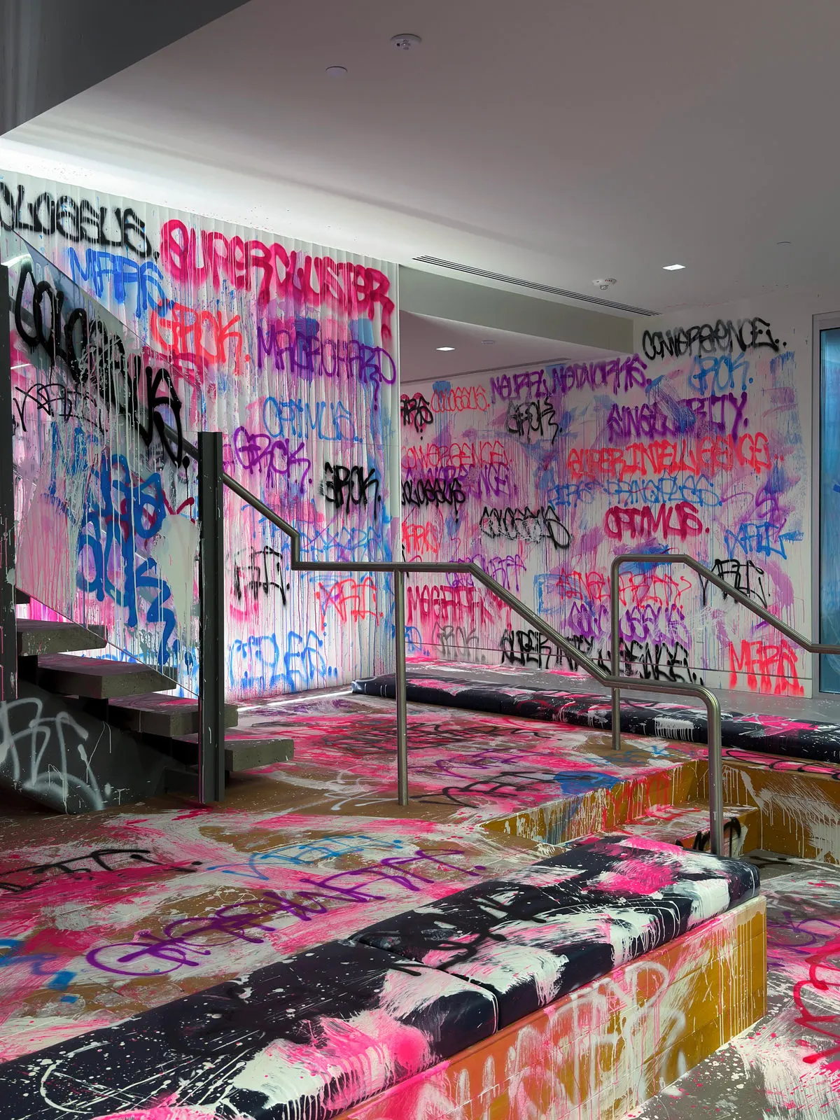 Layered fluorescent graffiti surrounding the staircase and raised platform