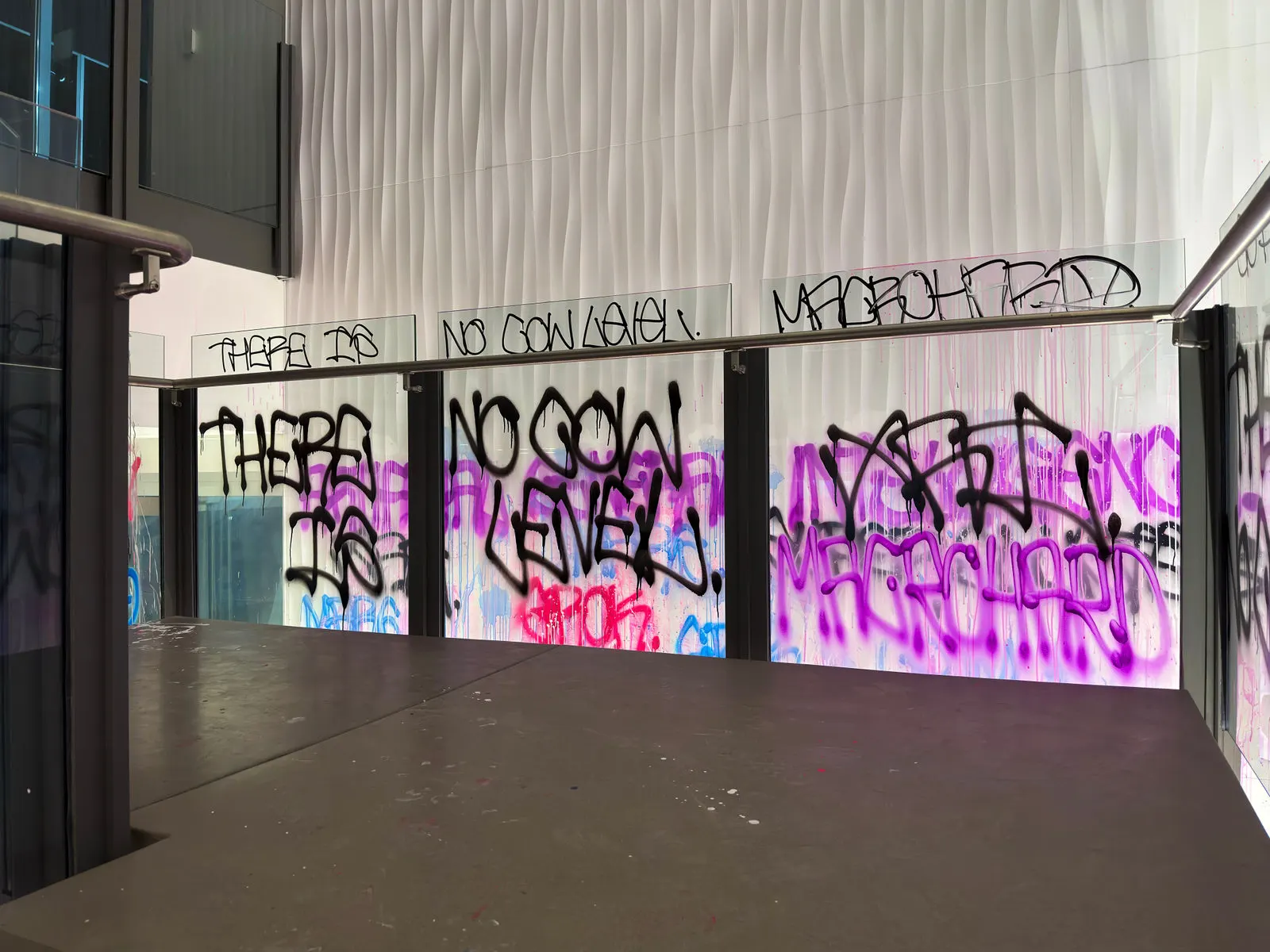 Graffiti-covered xAI office entrance seen through a glass partition